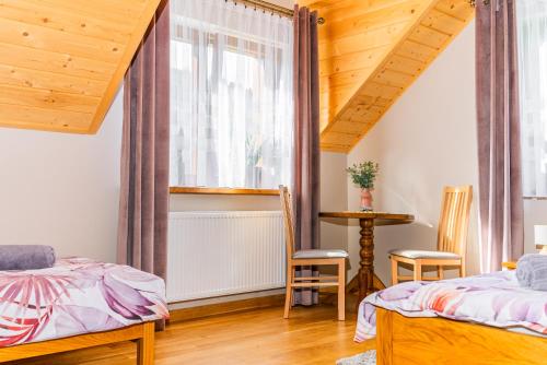 1 Schlafzimmer mit 2 Betten und einem Fenster in der Unterkunft Willa na Wzgórzu in Piwniczna-Zdrój