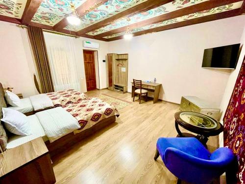 a bedroom with a bed and a table and a chair at Mevlana Hotel in Samarkand