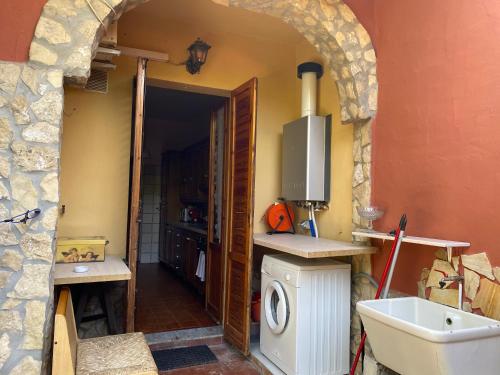 een keuken met een wastafel en een wasmachine bij Villa Franca in Capoterra