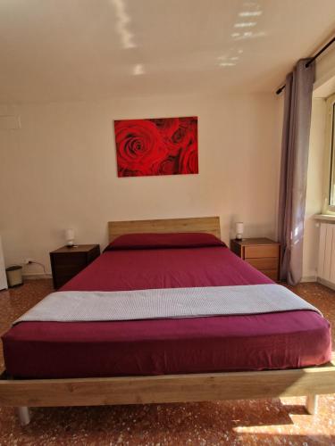 a bedroom with a bed with a red painting on the wall at CorneliaGuestHouse in Rome