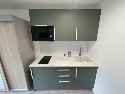 a small kitchen with a sink and a microwave at 01.Studio#Creteil#Loft#Cinéma in Créteil