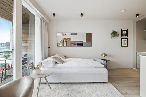 a white bedroom with a bed and a window at Brand New Downtown Harbor Apartment in Reykjavík