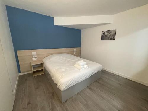 a small bedroom with a bed and a blue wall at 01.Studio#Creteil#Loft#Cinéma in Créteil