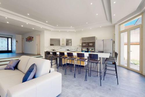 un salon avec un canapé blanc et une cuisine dans l'établissement 01.Studio#Creteil#Loft#Cinéma, à Créteil