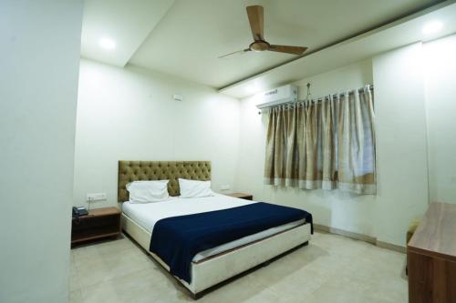 a bedroom with a bed with a blue blanket at Hotel Anand in Kolhapur