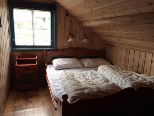 a bedroom with a large bed in a wooden room at Haugland Gard in Haugaland