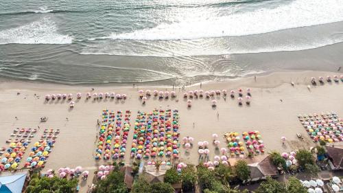 eine Luftaufnahme eines Strandes mit Sonnenschirmen in der Unterkunft Seminyak Beach Tropical Hideaway Apartment in Seminyak