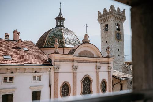 a church with a clock tower and a building at Hotel Venezia in Trento