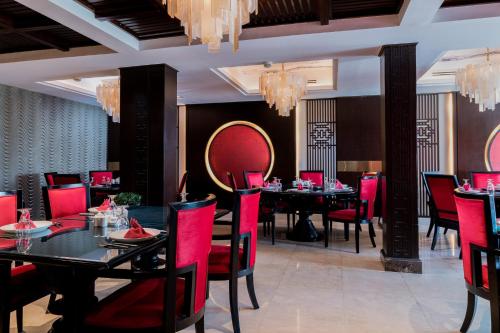 a restaurant with red chairs and tables in a room at Holiday Inn Kuwait by IHG in Kuwait