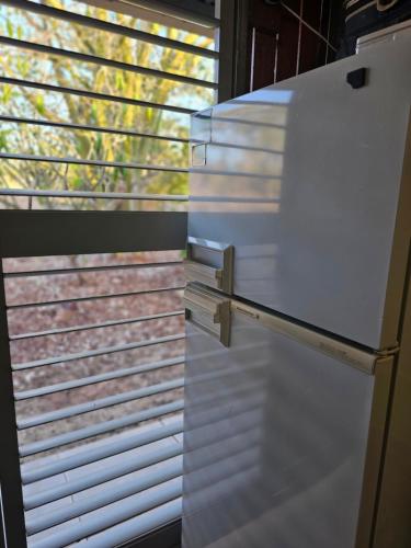 a white refrigerator in front of a window at Almost Off Grid Tranquillity in Katherine