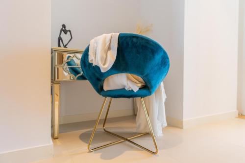a blue chair sitting in front of a desk at HiGuests - Colorful Apartment in Bluewaters Close to Beach in Dubai