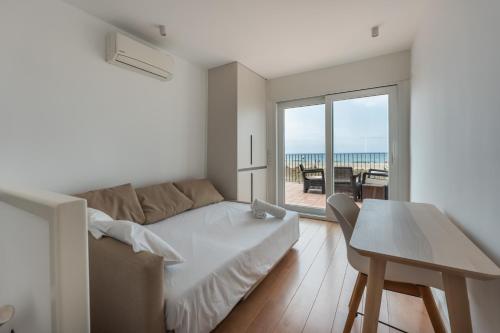 a white living room with a couch and a table at Beach Villa Cristina by HHBCN in Castelldefels