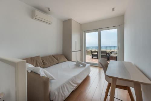 a white living room with a couch and a table at HHBCN Beach House Castelldefels #3 in Castelldefels