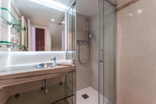 a bathroom with a sink and a shower at Beach Villa Cristina by HHBCN in Castelldefels