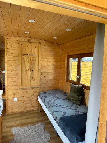 Cette petite chambre comprend un lit dans une cabane en bois. dans l'établissement Chez Célia, Roulotte en Champagne, à Fleury-la-Rivière