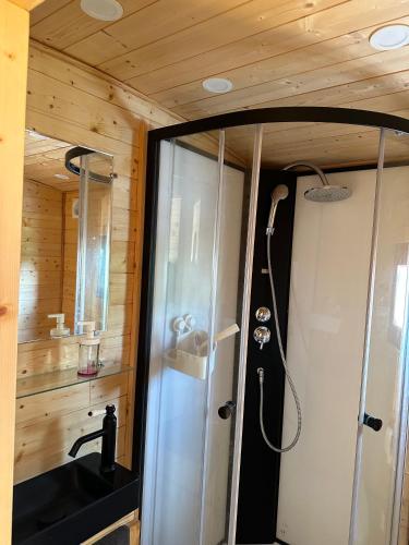 La salle de bains est pourvue d'une douche et d'un lavabo. dans l'établissement Chez Célia, Roulotte en Champagne, à Fleury-la-Rivière