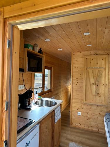 - une cuisine dans une cabane en rondins avec évier dans l'établissement Chez Célia, Roulotte en Champagne, à Fleury-la-Rivière