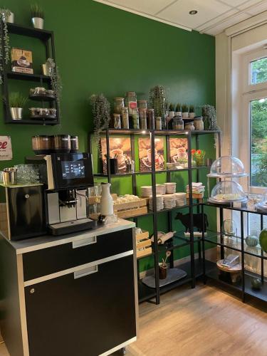 a shop with green walls and shelves with pots and pans at ACHAT Hotel Monheim am Rhein in Monheim