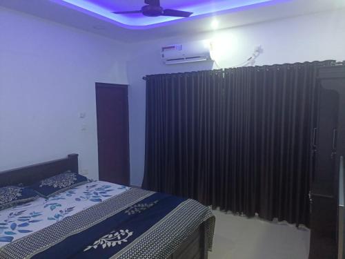 a bedroom with a bed and a black curtain at Rain Homestay in Alleppey