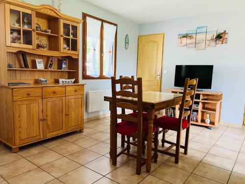 une cuisine avec une table et des chaises et une télévision dans l'établissement Gite Les Garbails, à Le Barp