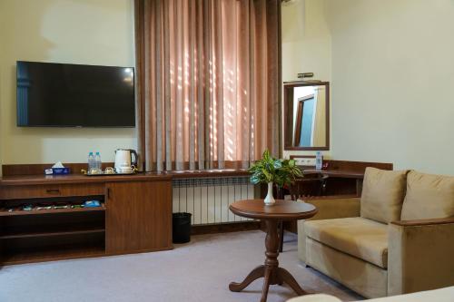 a living room with a chair and a television at Sangzor Boutique Hotel in Samarkand