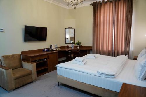 a bedroom with a bed and a desk and a chair at Sangzor Boutique Hotel in Samarkand