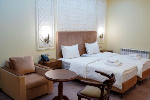 a hotel room with a bed and a chair at Sangzor Boutique Hotel in Samarkand