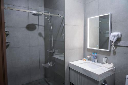 a bathroom with a shower and a sink and a mirror at Sangzor Boutique Hotel in Samarkand