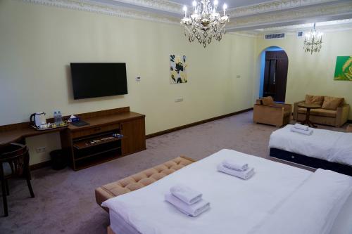 a hotel room with two beds and a television at Sangzor Boutique Hotel in Samarkand