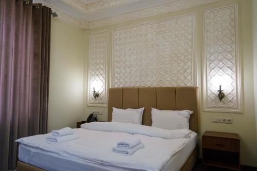 a bedroom with a bed with two towels on it at Sangzor Boutique Hotel in Samarkand