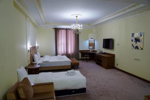 a hotel room with two beds and a desk at Sangzor Boutique Hotel in Samarkand