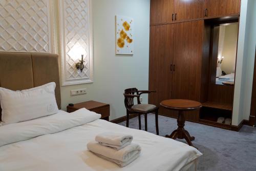 a hotel room with a bed with towels on it at Sangzor Boutique Hotel in Samarkand