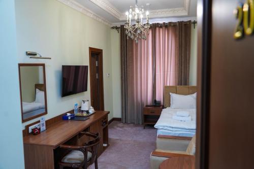 a hotel room with a bed and a desk and a mirror at Sangzor Boutique Hotel in Samarkand