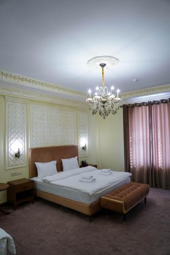 a bedroom with a large bed and a chandelier at Sangzor Boutique Hotel in Samarkand