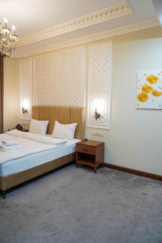 a bedroom with a large bed and two windows at Sangzor Boutique Hotel in Samarkand