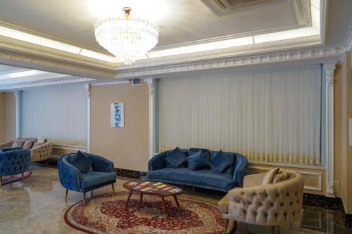 a living room with blue furniture and a chandelier at Sangzor Boutique Hotel in Samarkand