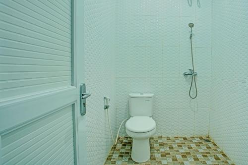 a bathroom with a toilet and a shower at Capital O 92990 Nena Kostel Syariah in Padang