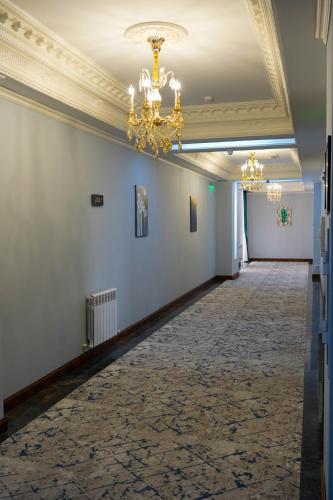 a hallway with white walls and a chandelier at Sangzor Boutique Hotel in Samarkand