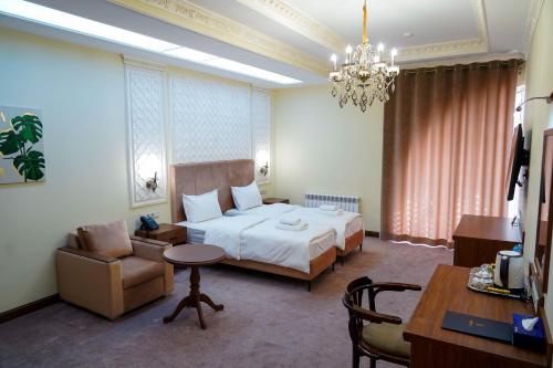 a hotel room with a bed and a chair and a desk at Sangzor Boutique Hotel in Samarkand
