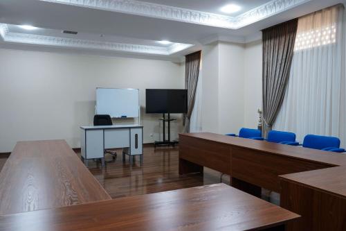 a meeting room with tables and chairs and a screen at Sangzor Boutique Hotel in Samarkand
