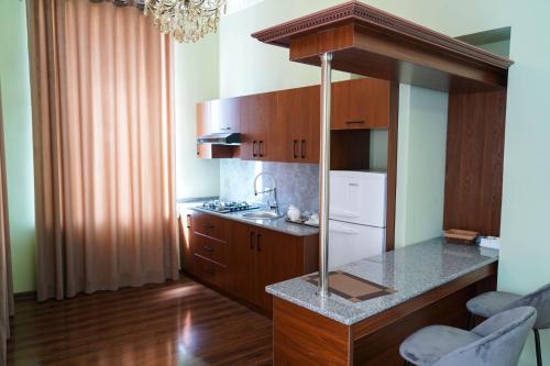 a kitchen with wooden cabinets and a white refrigerator at Sangzor Boutique Hotel in Samarkand