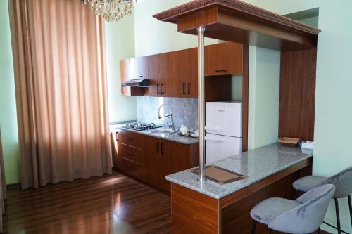a kitchen with wooden cabinets and a white refrigerator at Sangzor Boutique Hotel in Samarkand