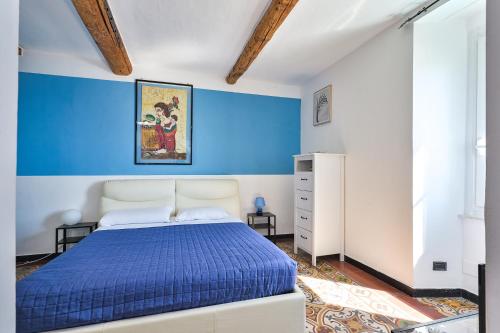 a bedroom with a blue accent wall and a bed at IL RIFUGIO SUL MARE - GenovaInRelax in Genova