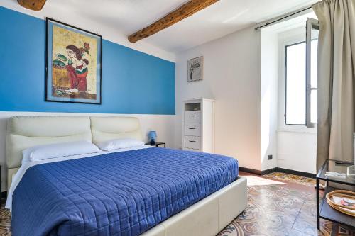 a blue and white bedroom with a bed and a window at IL RIFUGIO SUL MARE - GenovaInRelax in Genova