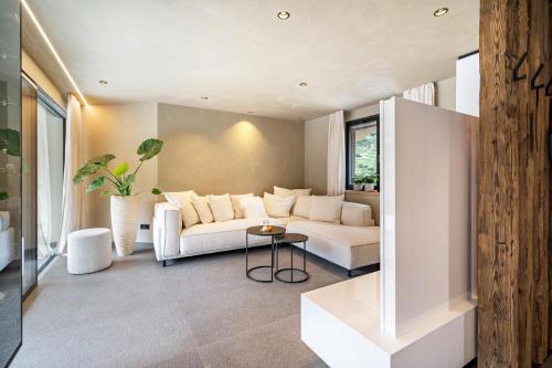 a living room with a white couch and a table at Boutique Hotel AMARIL in Castelbello-ciardes