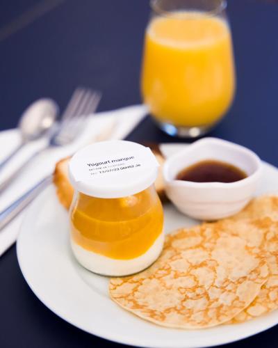 a plate of food with a bottle of honey and chips at Hotel Saint Regis in Chalon-sur-Saône
