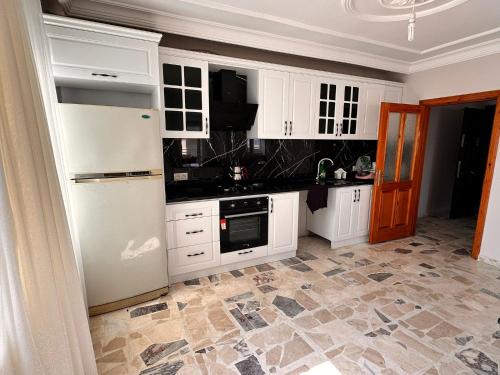 a kitchen with white cabinets and a tile floor at Апартаменты in Tömük