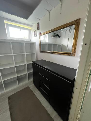 a bathroom with a black dresser and a mirror at Modern DIY apartment in Petrikyula