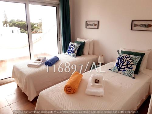 zwei Betten in einem Zimmer mit großem Fenster in der Unterkunft Beach Apartment Terrace in Vilamoura