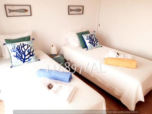 - 2 lits dans une chambre aux murs blancs dans l'établissement Beach Apartment Terrace, à Vilamoura